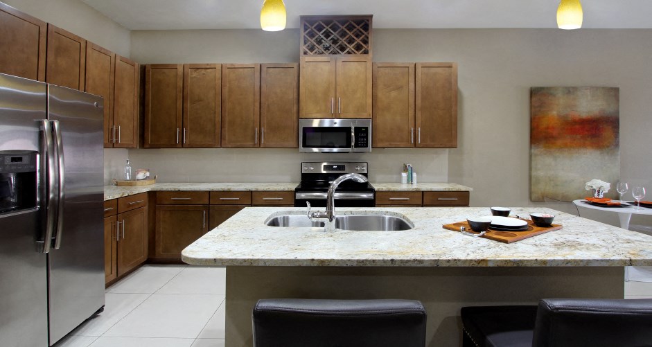 Luxury apartments with granite countertops, stainless steel appliances, built-in wine rack, kitchen island, and porcelain tile floor at Bellemeade Apartments in west Des Moines