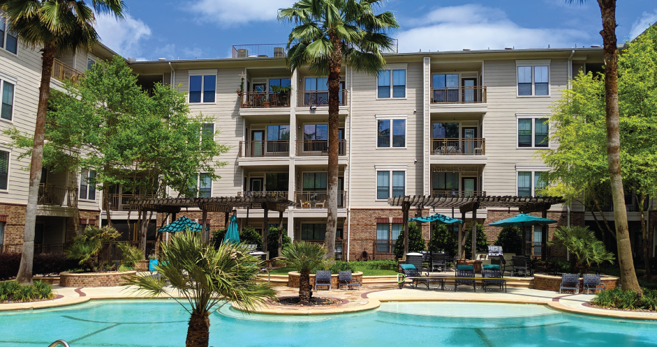 Luxury swimming pool with cabanas, poolside lounges, grilling stations, palm trees and beautiful landscaping at The Voss Apartments in Houston.