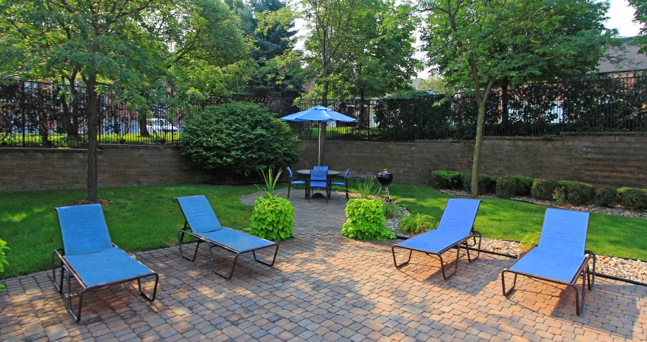Luxury apartments with lush landscaping, picnic area, pool-side lounge chairs, park-like setting, and scenic views at Lenox Village Apartments in Lincoln, Nebraska