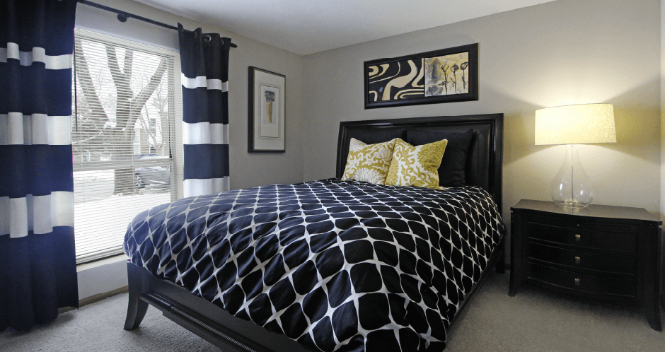 Spacious master bedroom with walk-in closet, master bathroom, and gray wall color at The Vanderbilt Apartments in Omaha, Nebraska