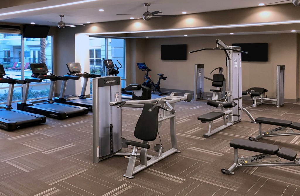 Luxury apartments with huge fitness center with multiple varieties of workout machines and equipment at Tuscany Walk Apartments in Houston Texas.