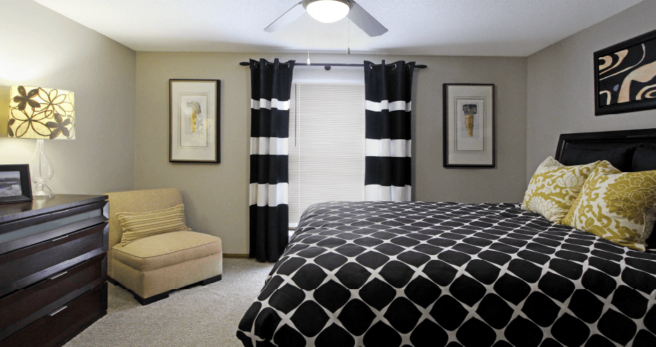 Spacious master bedroom with walk-in closet, master bathroom, and gray wall color at The Vanderbilt Apartments in Omaha, Nebraska