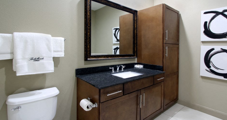 Luxury bathroom with oval soaking tub, glass shower, granite countertops and linen closet at Bellemeade Apartments in west Des Moines