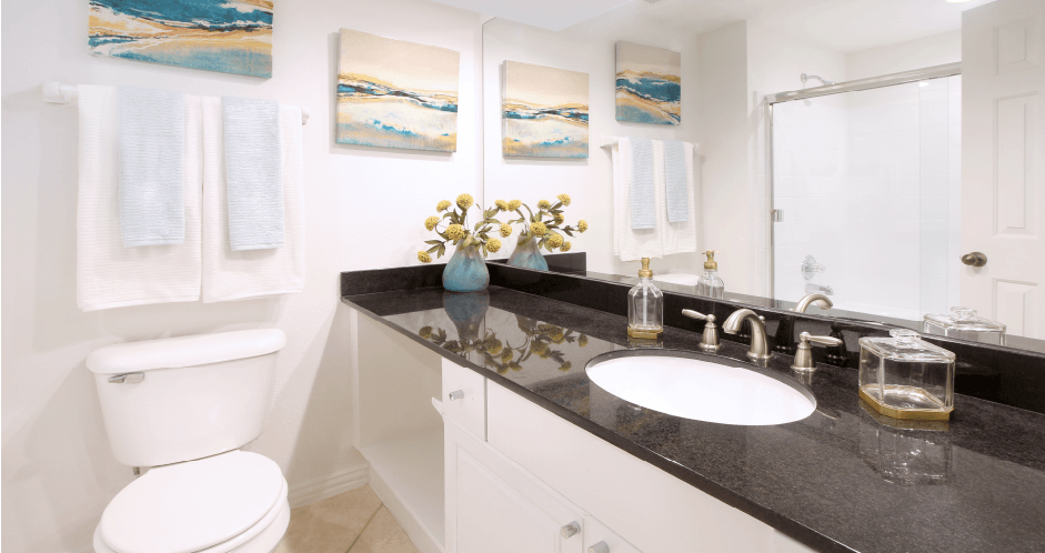 Luxury bathroom with oval soaking tub with glass enclosure, granite vanity top, and glass shower at Tuscany Row Townhomes in Houston.