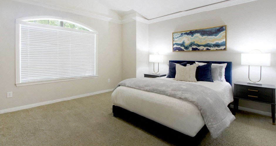 Huge bedroom, spacious bedroom with vaulted ceiling, ceiling fan, walk-in closet, and attached bathroom at Tuscany Villas Townhomes in Houston.