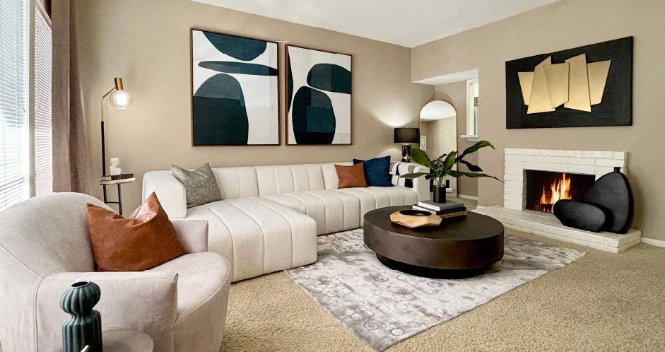 Spacious living room with oversized windows, lots of natural light, and woodburning fireplace at Woodlake Oaks Apartments in Houston.