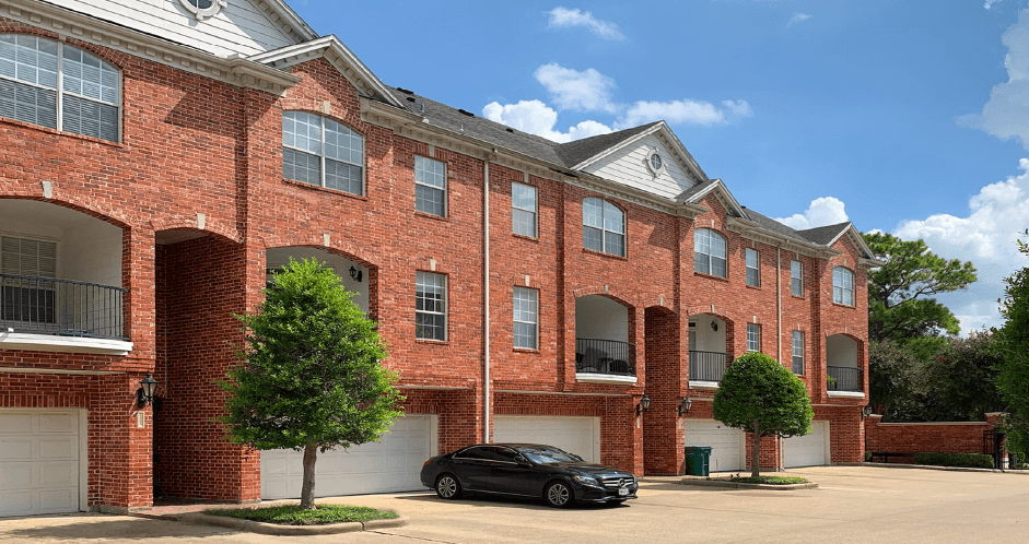 Luxury townhomes in a gated community with red brick exteriors and attached 2-car garages at Tuscany Row Townhomes in Houston.