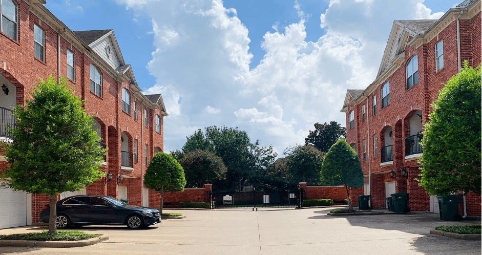 Luxury townhomes in a gated community with red brick exteriors and attached 2-car garages at Tuscany Row Townhomes in Houston.