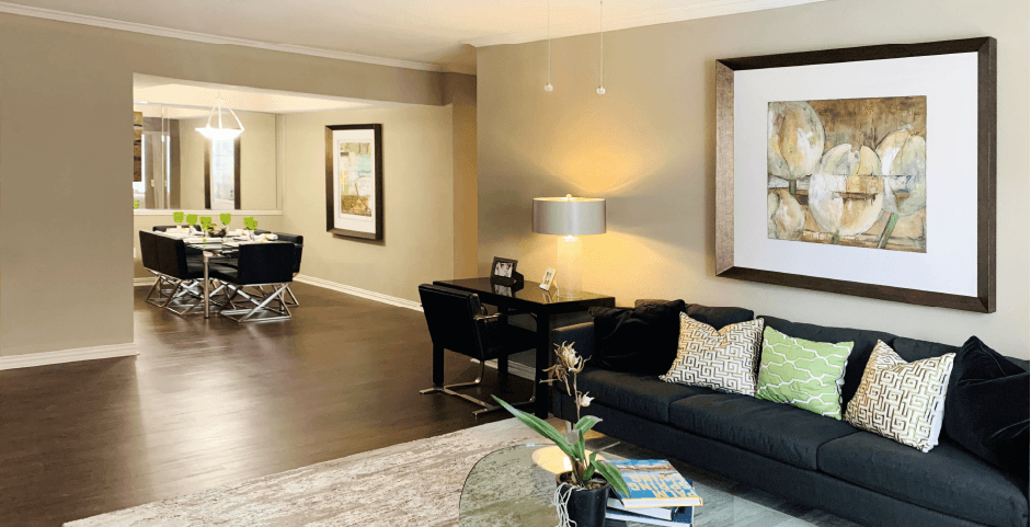 Spacious living room and dining room with ceiling fan, 9-foot ceilings and wood grain plank flooring at The Lanesborough Apartments in Houston.