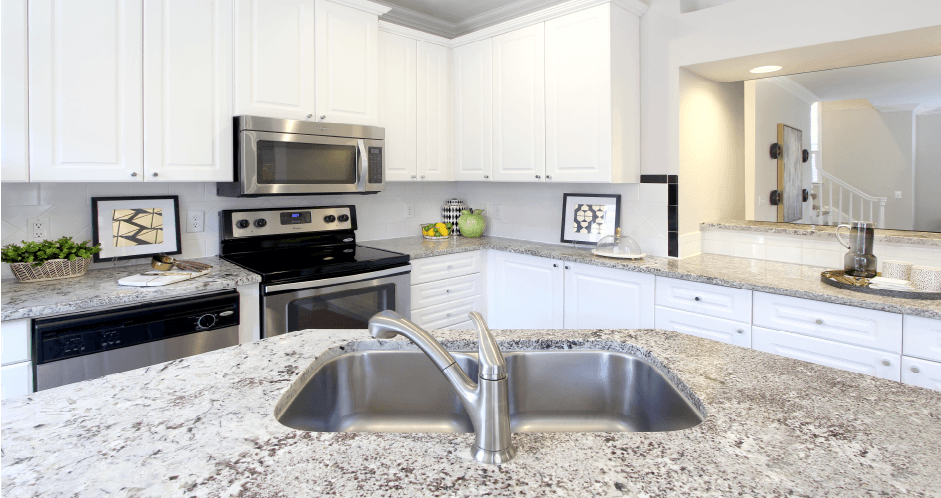 Spacious kitchen with island, granite countertops, custom home cabinets, French doors, smooth glass top stove, spacious pantries, breakfast bar and stainless-steel appliances at Tuscany Row Townhomes in Houston.