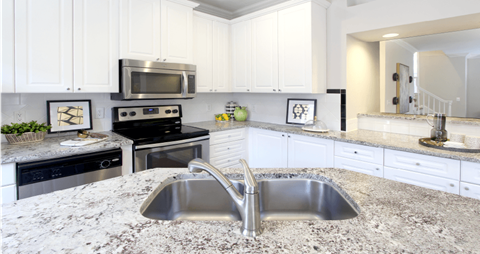 a large kitchen with granite counter tops and stainless steel appliances
