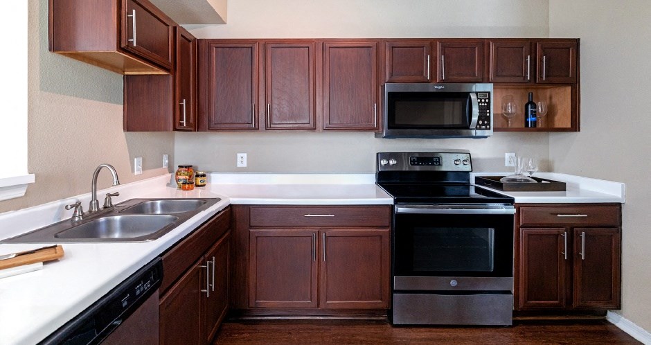 Spacious kitchen with stainless steel appliances and plank wood floors at Village on the Parkway Apartments