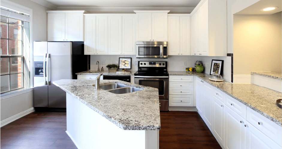 Spacious kitchen with island, granite countertops, custom home cabinets, French doors, smooth glass top stove, spacious pantries, breakfast bar and stainless-steel appliances at Tuscany Row Townhomes in Houston.