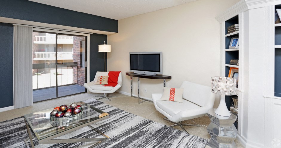 Spacious living room with colored feature wall and built-in shelves at Embassy Park Apartments in Omaha, Nebraska