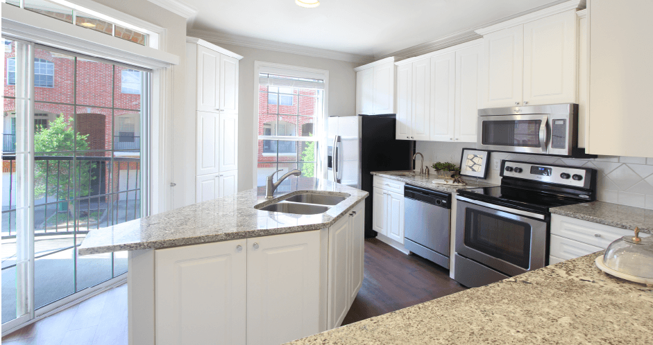 Spacious kitchen with island, granite countertops, custom home cabinets, French doors, smooth glass top stove, spacious pantries, breakfast bar and stainless-steel appliances at Tuscany Row Townhomes in Houston.