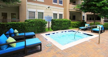 Luxury apartments with palm trees, spa, hot tub, spacious sundeck with poolside lounge chairs, beautiful landscaping, and fountains at Villa Piana Apartments in Dallas - Photo Gallery 25