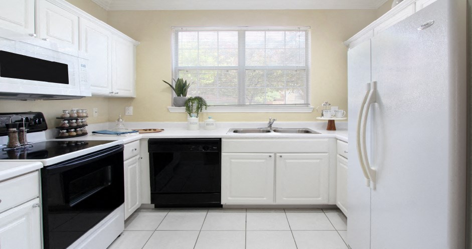 Luxury apartments with bright white kitchen, u-shaped kitchen, white cabinets, and side-by-side refrigerator at TurtleCreek apartments in West Des Moines, Iowa