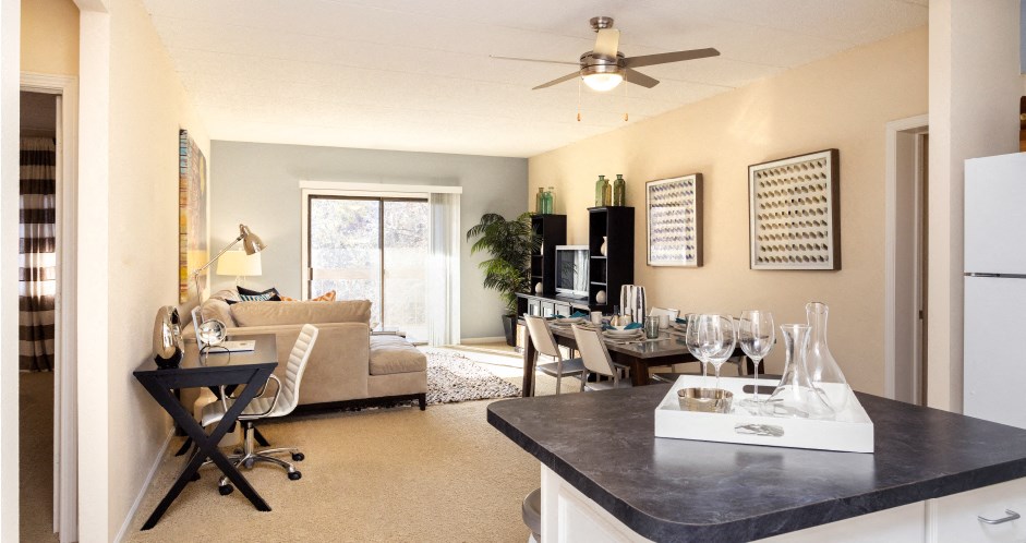 Apartments in central Omaha with open floor plan, open layout, condo-style layout, spacious living room, kitchen island, prep island, and colored feature wall at Embassy Park Apartments in Omaha, Nebraska