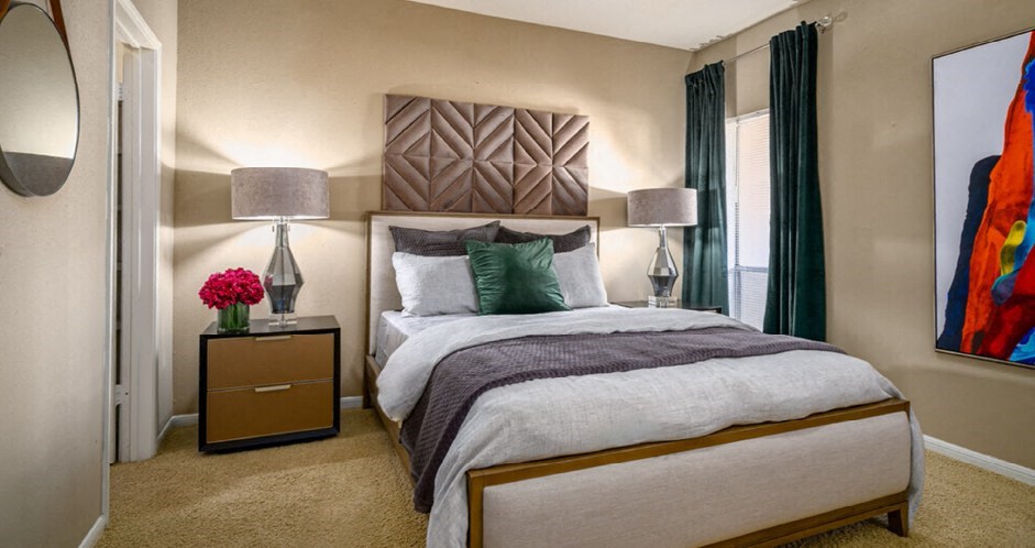 Spacious bedroom with walk-in closet and cozy grey wall color at Woodlake Oaks Apartments in Houston.