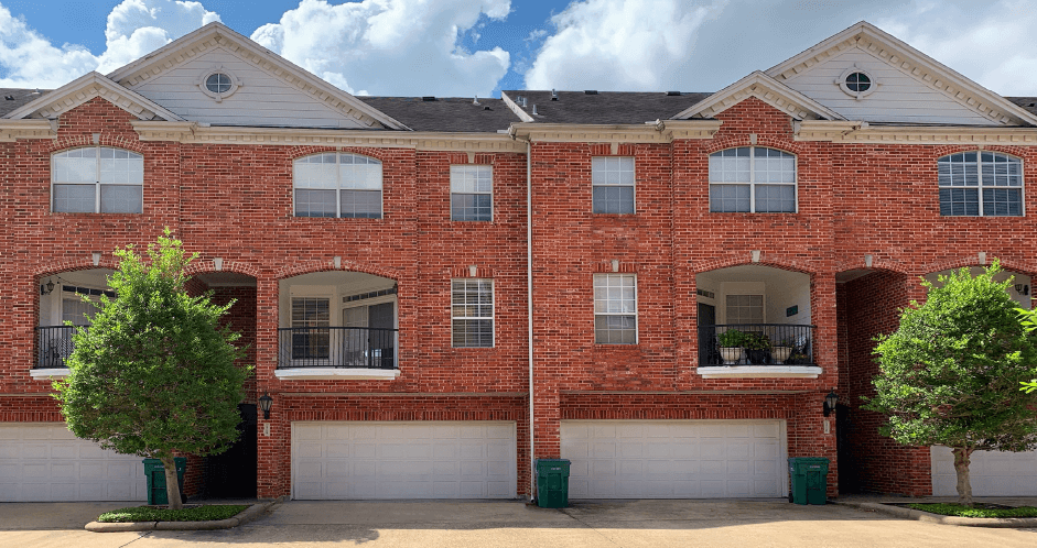Luxury townhomes in a gated community with red brick exteriors and attached 2-car garages at Tuscany Row Townhomes in Houston.