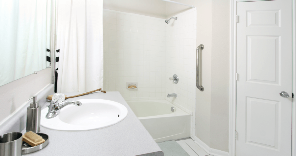 Spacious bathroom with white cabinets, linen closet, extra cabinet space, soaking tub and tiled shower at Breckenridge Apartments in Omaha, Nebraska