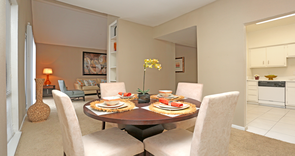 Spacious floor plan, spacious dining room with oversized windows, lots of natural light, bright white kitchen and built-in shelves at Woodlake on the Bayou Apartments in Houston.