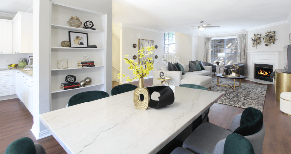 Spacious dining room with built-in bookshelves, hardwood floors, spacious living room with wood-burning fireplace at Tuscany Row Apartments in Houston.