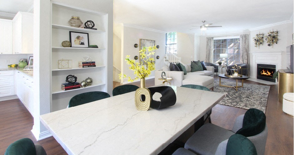 Spacious dining room with built-in bookshelves, hardwood floors, spacious living room with wood-burning fireplace at Tuscany Villas Apartments in Houston.