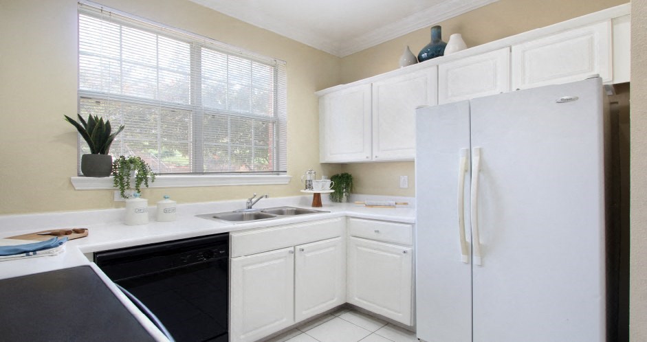 Spacious u-shaped kitchen, luxury apartments with bright white kitchen and side-by-side refrigerator at Saddlebrook apartments in Urbandale, Iowa
