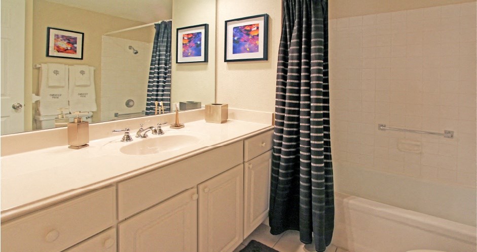 Bathroom with white cabinets, lots of cabinet space, soaking tub, and tiled floor at Embassy Park Apartments in Omaha, Nebraska
