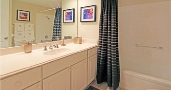 Bathroom with white cabinets, lots of cabinet space, soaking tub, and tiled floor at Embassy Park Apartments in Omaha, Nebraska - Photo Gallery 32