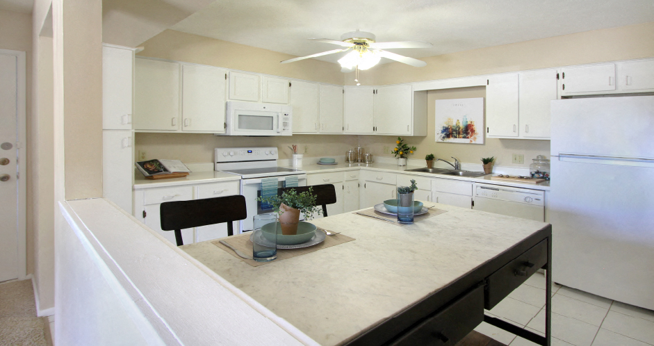 Spacious kitchen with lots of cabinet space, lots of counter space, white kitchen cabinets, bright white kitchen, porcelain tile floor, huge kitchen at Alpine Village Apartments in La Vista, Nebraska