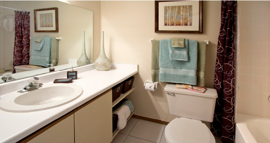 Bathroom with extra storage space, built-in shelves, tile floors and tile showers at LionsHead Apartments in Omaha, Nebraska