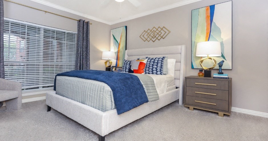 Spacious bedroom with gray colored walls, large windows and walk-in closet, at The Dorchester Apartments in Dallas Texas