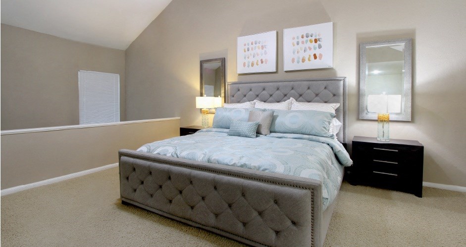 Huge master bedroom with vaulted ceiling and loft style layout with attached master bathroom and walk-in closet at Woodlake on the Bayou Apartments in Houston.