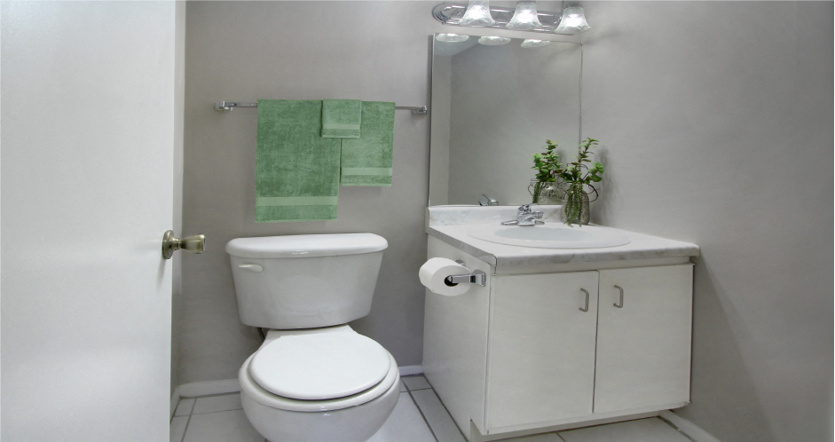 Half bath with white cabinets, tiled floor, and gray wall color at Inwood Apartments in La Vista, Nebraska