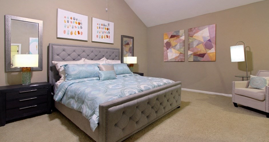 Huge master bedroom with vaulted ceiling and loft style layout with attached master bathroom and walk-in closet at Woodlake on the Bayou Apartments in Houston.