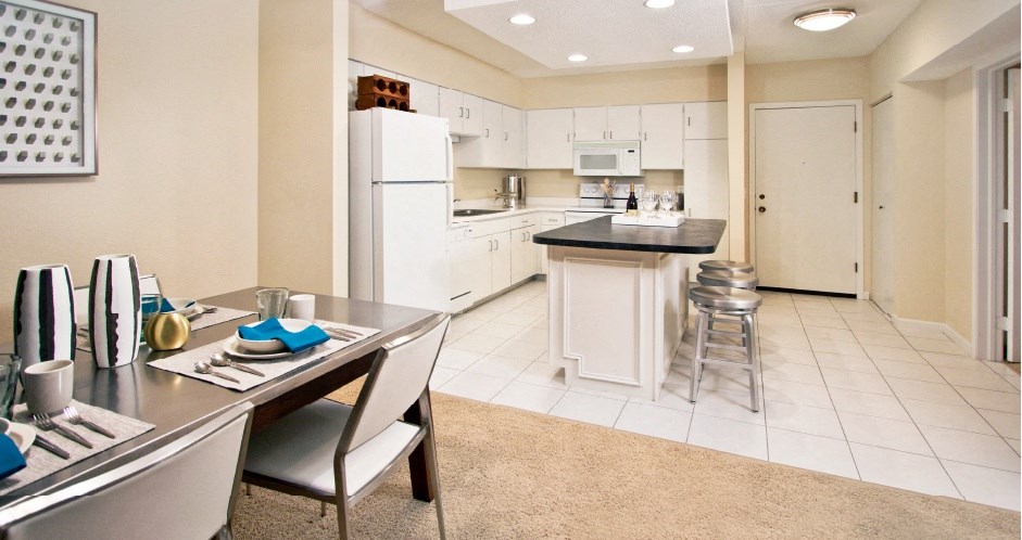 Spacious dining room and spacious kitchen with white cabinets, lots of cabinet space, lots of counter space, kitchen island, prep island at Embassy Park Apartments in Omaha, Nebraska