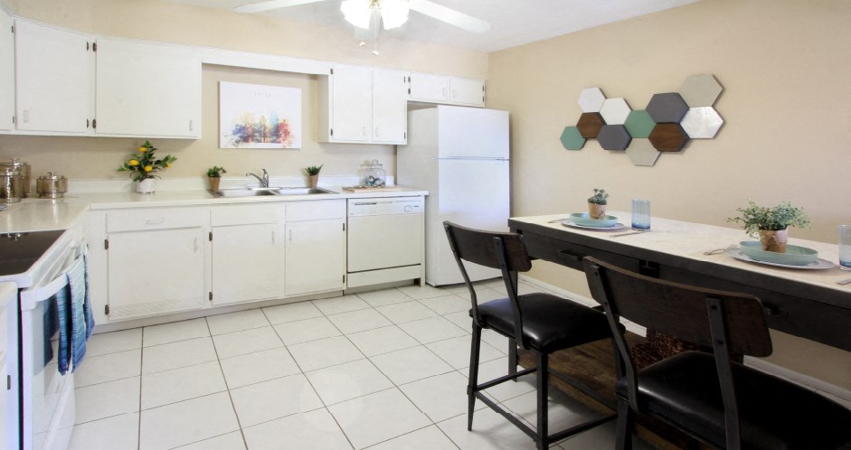 Spacious kitchen with lots of cabinet space, lots of counter space, white kitchen cabinets, bright white kitchen, porcelain tile floor, huge kitchen at Alpine Village Apartments in La Vista, Nebraska