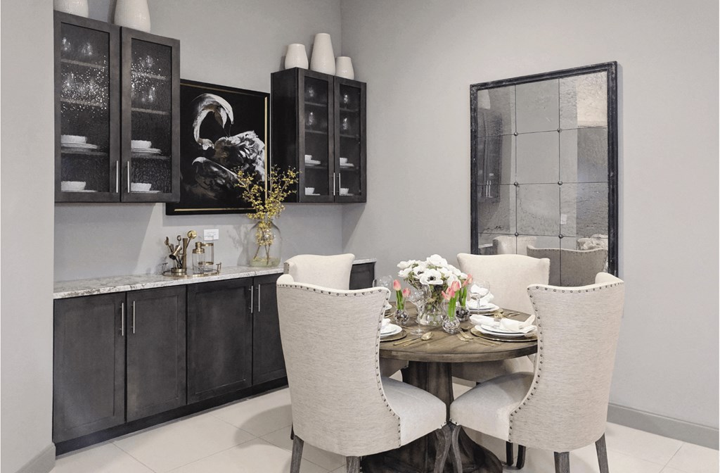 A dining nook with a sideboard and built-in glass shelves