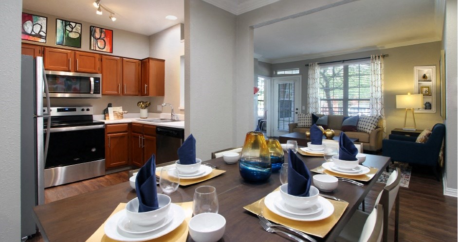 Luxury apartments with wood grain plank floors, dining room, u-shaped kitchen, 9-foot ceilings, gray colored walls, and built-in shelves, at Lenox Village Apartments in Lincoln, Nebraska