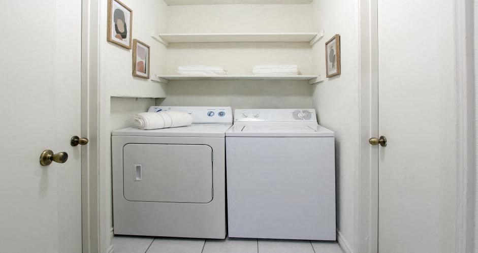 a white washer and dryer in a white laundry room