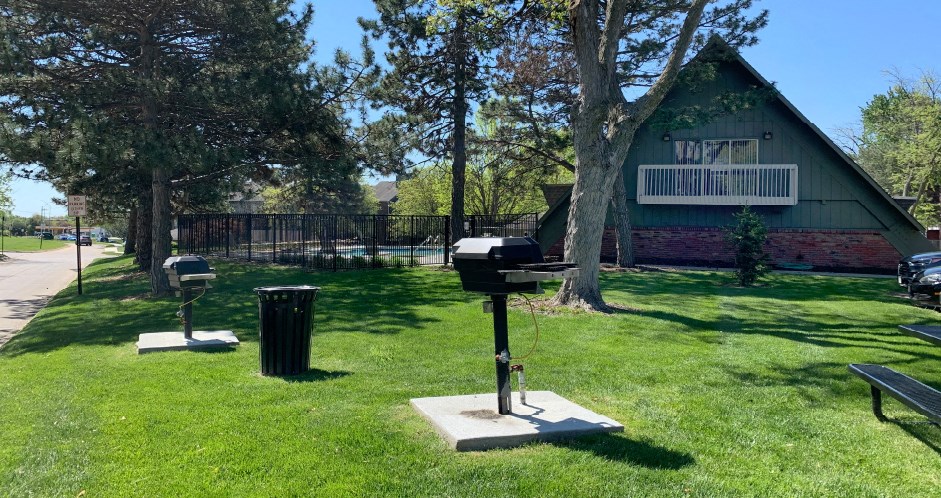 Apartments with grilling station, picnic area, park-like setting with lots of trees, beautiful landscaping, lush landscaping, and scenic views at Alpine Village Apartments in La Vista, Nebraska