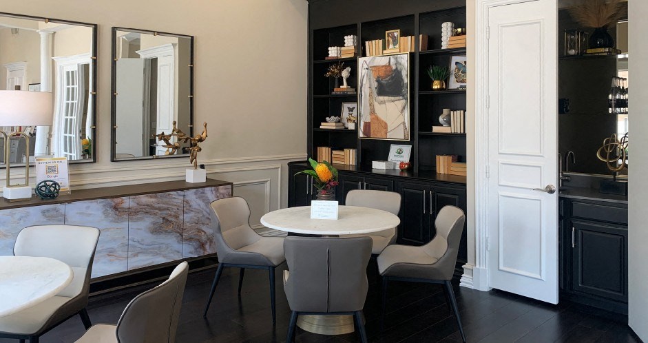 a dining room with a table and chairs and a bookshelf in the background