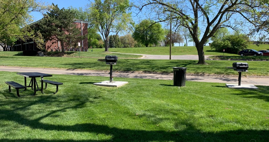 Apartments with grilling station, picnic area, park-like setting with lots of trees, beautiful landscaping, lush landscaping, and scenic views at Alpine Village Apartments in La Vista, Nebraska