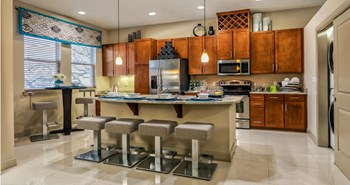 Luxury apartments with spacious kitchen with granite countertops, stainless steel appliances, built-in wine rack, kitchen island, and porcelain tile floor at Villa Piana Apartments in Dallas - Photo Gallery 10
