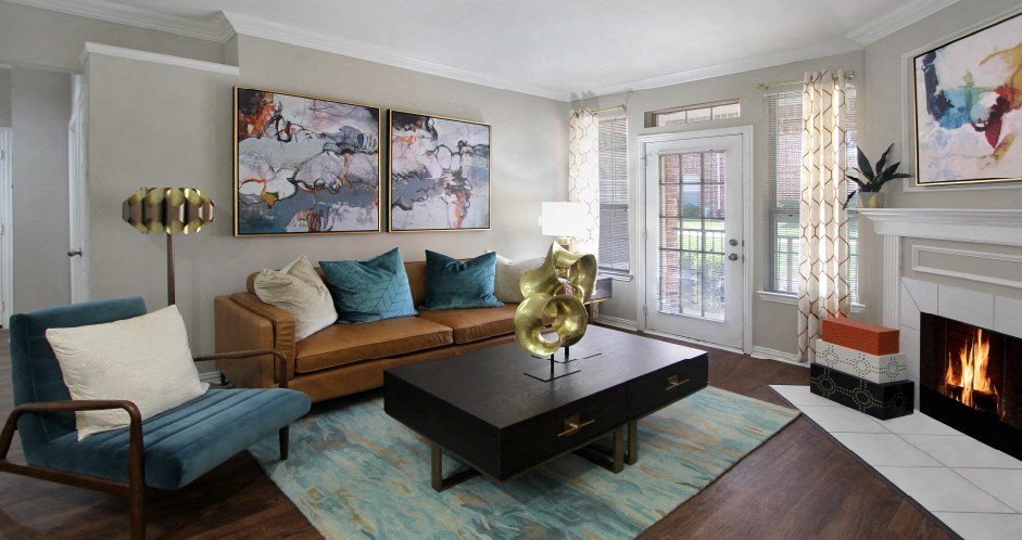 Living room with wood-burning fireplace, plank wood floors, French door, and 9-foot ceilings at Prestonbridge Apartments in North Dallas