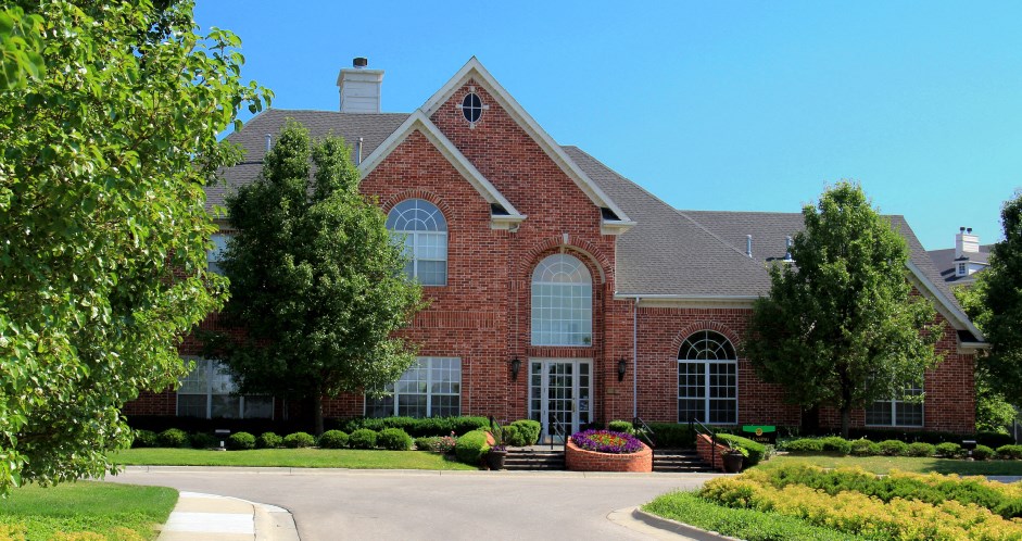 Luxury apartments with red brick exterior, lush landscaping, park-like setting, and scenic views at Lenox Village Apartments in Lincoln, Nebraska