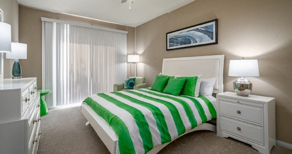 Spacious bedroom with walk-in closet and gray painted walls at Woodlake on the Bayou Apartments
