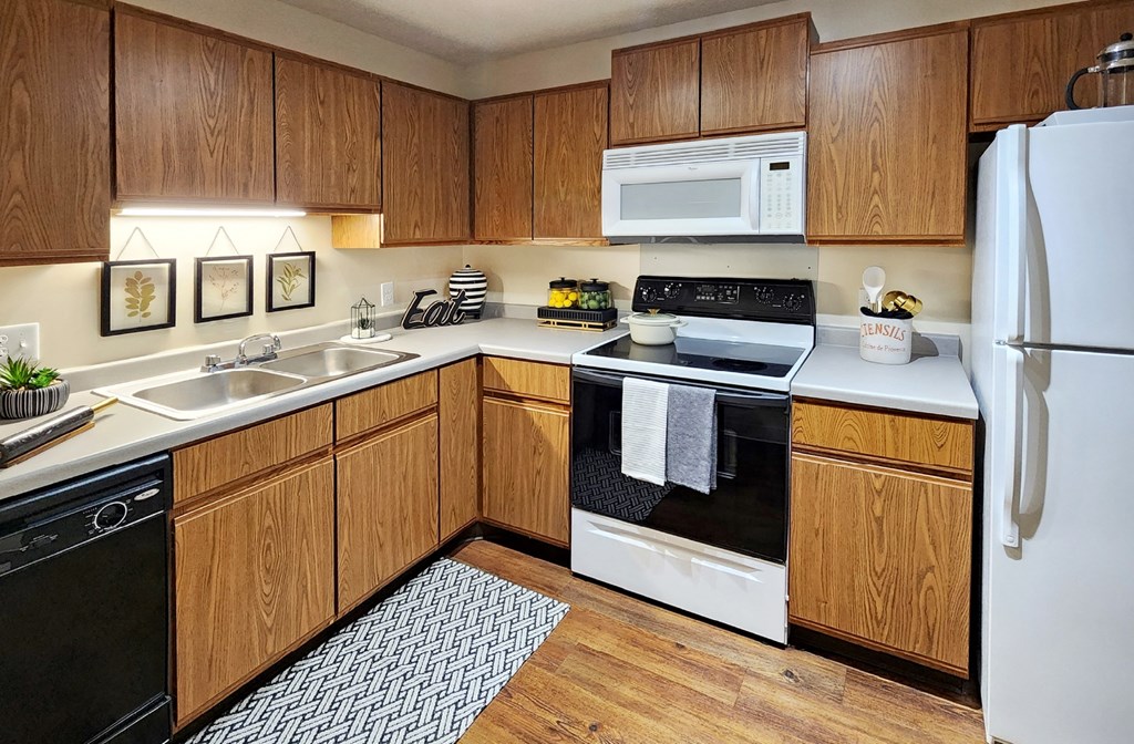 Kitchen with honey brown toned cabinets and lots of cabinet space at Claremont Apartments in Minnetonka, Minnesota